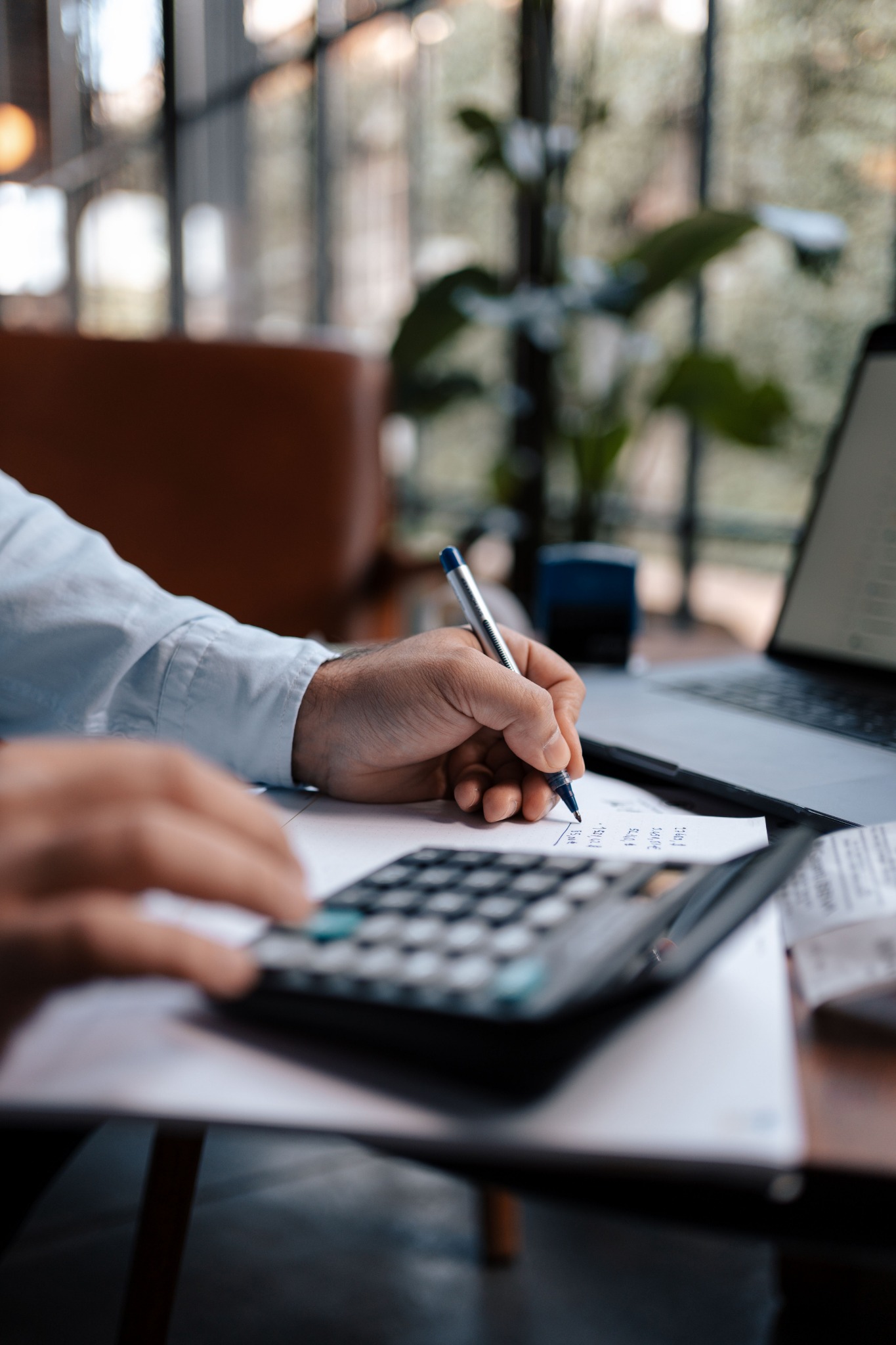 Profesional contable trabajando con calculadora, documentación y computadora